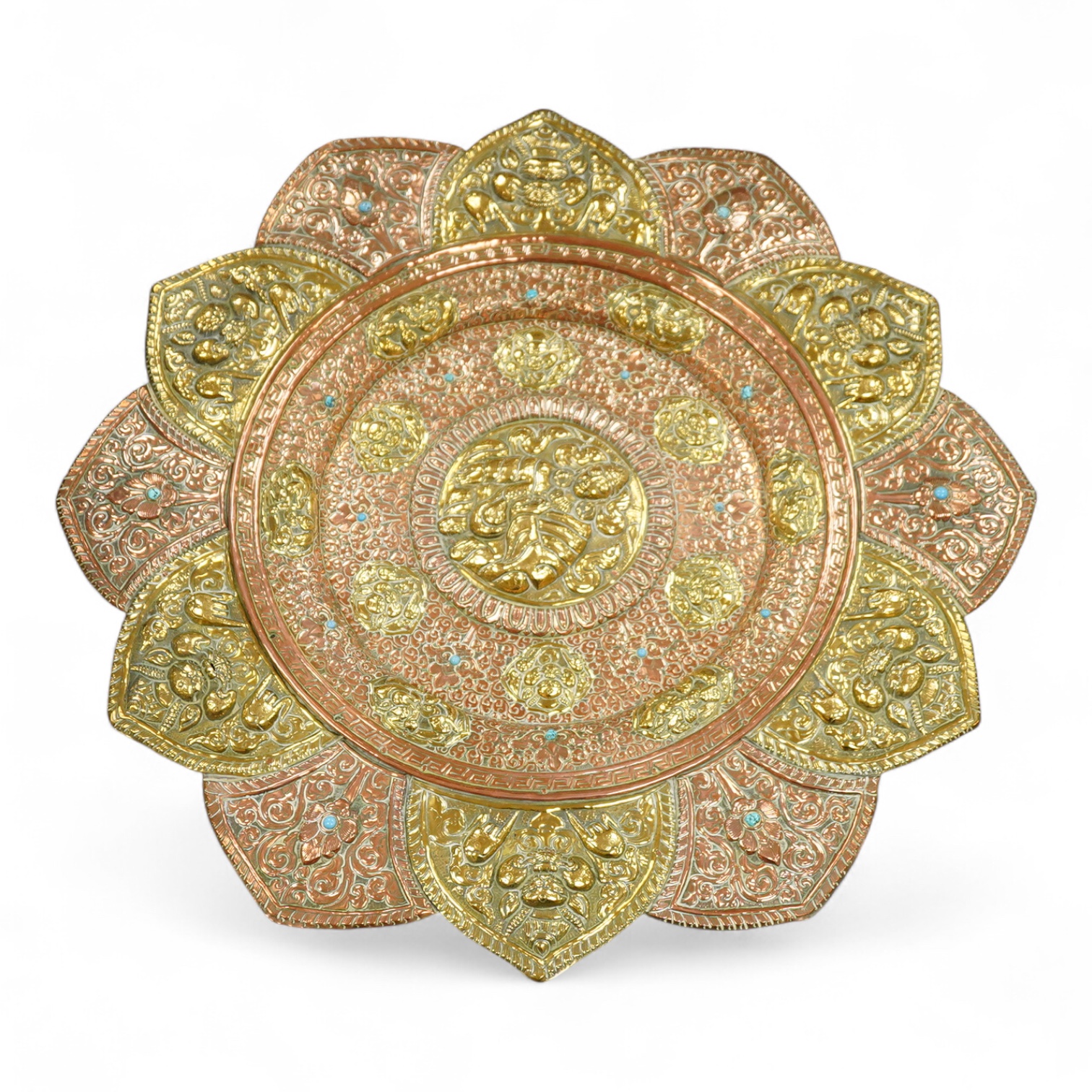 A large Nepalese brass and copper embossed tray, first half 20th century, set with simulated turquoise cabochons, 68cm diameter